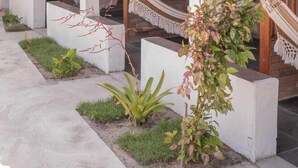 A covered outdoor area with a tiled roof, concrete steps, and a hammock. - Pousada Quintal da Praia  (Prado)