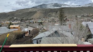 A residential area with houses, a wooden fence, and a mountain in the background. - Cozy loft in Gardiner with AC, WiFi and splendid views  (Gardiner)