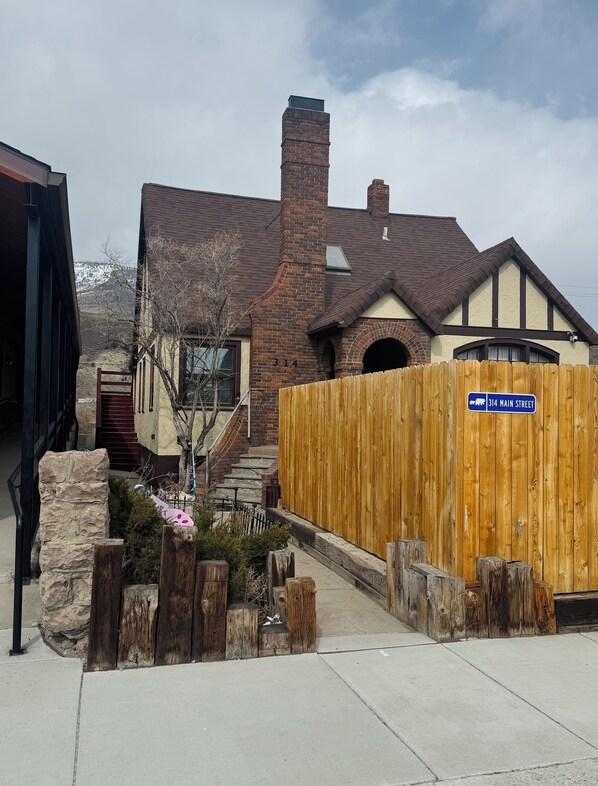 A residential house with a brick chimney, a wooden fence, and a street sign indicating "314 Main Street". - Cozy loft in Gardiner with AC, WiFi and splendid views (Gardiner)