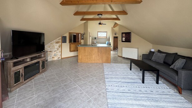 A spacious living area with a TV, wooden entertainment unit, and a sofa. - Cozy loft in Gardiner with AC, WiFi and splendid views  (Gardiner)