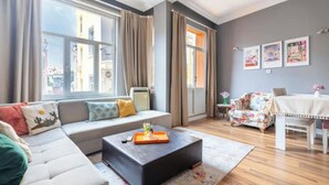 Ein modernes Wohnzimmer mit einer Couch, einem Couchtisch und einem floralen Sessel.