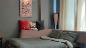 Ein modernes Schlafzimmer mit einem Bett, einem Couchtisch und einer Wandlampe.