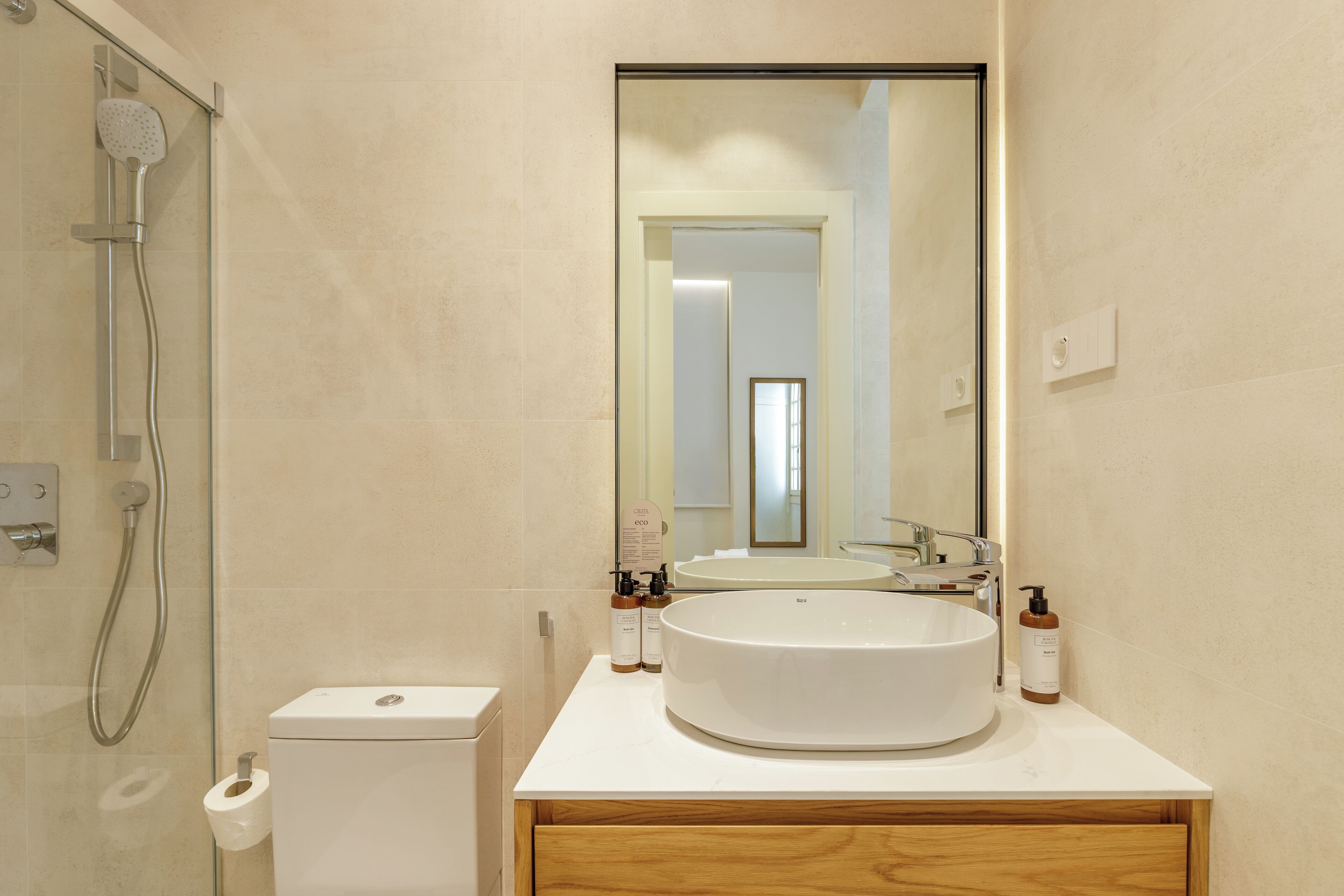 A bathroom with a toilet, bidet, and a sink with a mirror above it.