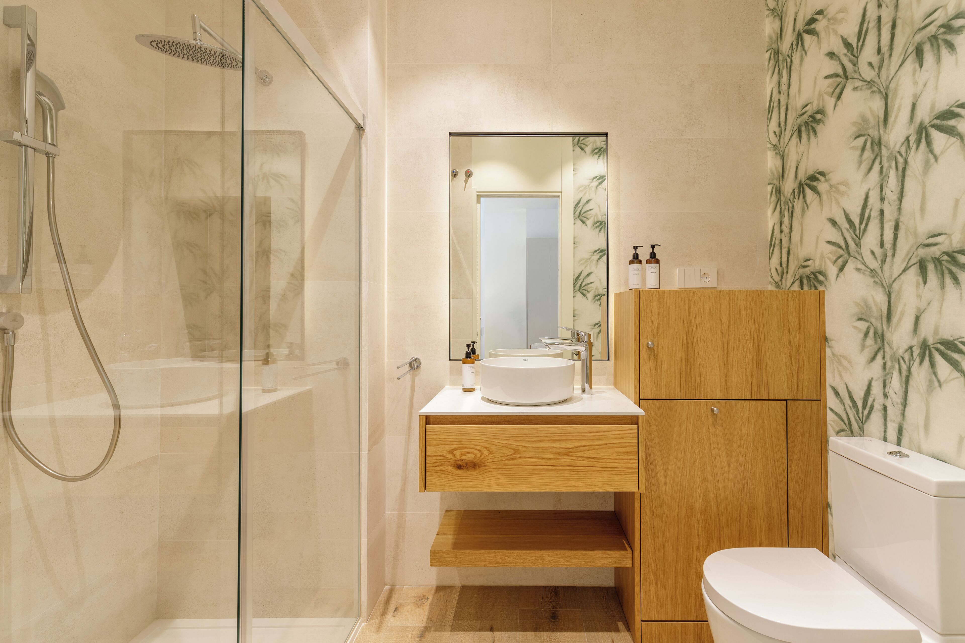 Une salle de bain moderne avec une douche à parois de verre, un meuble-lavabo en bois et des toilettes.