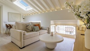 Een moderne woonkamer met een bank, een ronde salontafel en een dakraam.