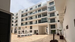 A modern multi-story building with a central courtyard. - Agadir Bay, a comfy apartment with pool (Agadir)