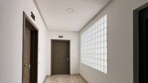 A hallway with a marble floor, a door labeled "201", and a window with a geometric pattern. - Agadir Bay, a comfy apartment with pool (Agadir)