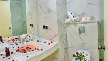 Een badkamer met een marmeren wastafel, douche en toilet.