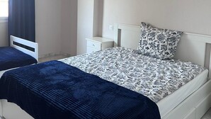 A bedroom with a bed, a nightstand, a dresser, and a window with curtains. - La Reserva de Marbella Penthouse  (Marbella)