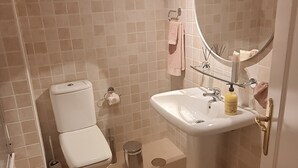 A bathroom with a toilet, sink, and mirror. - La Reserva de Marbella Penthouse  (Marbella)