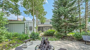 Une cour avec un foyer, deux bancs et un bâtiment en arrière-plan.