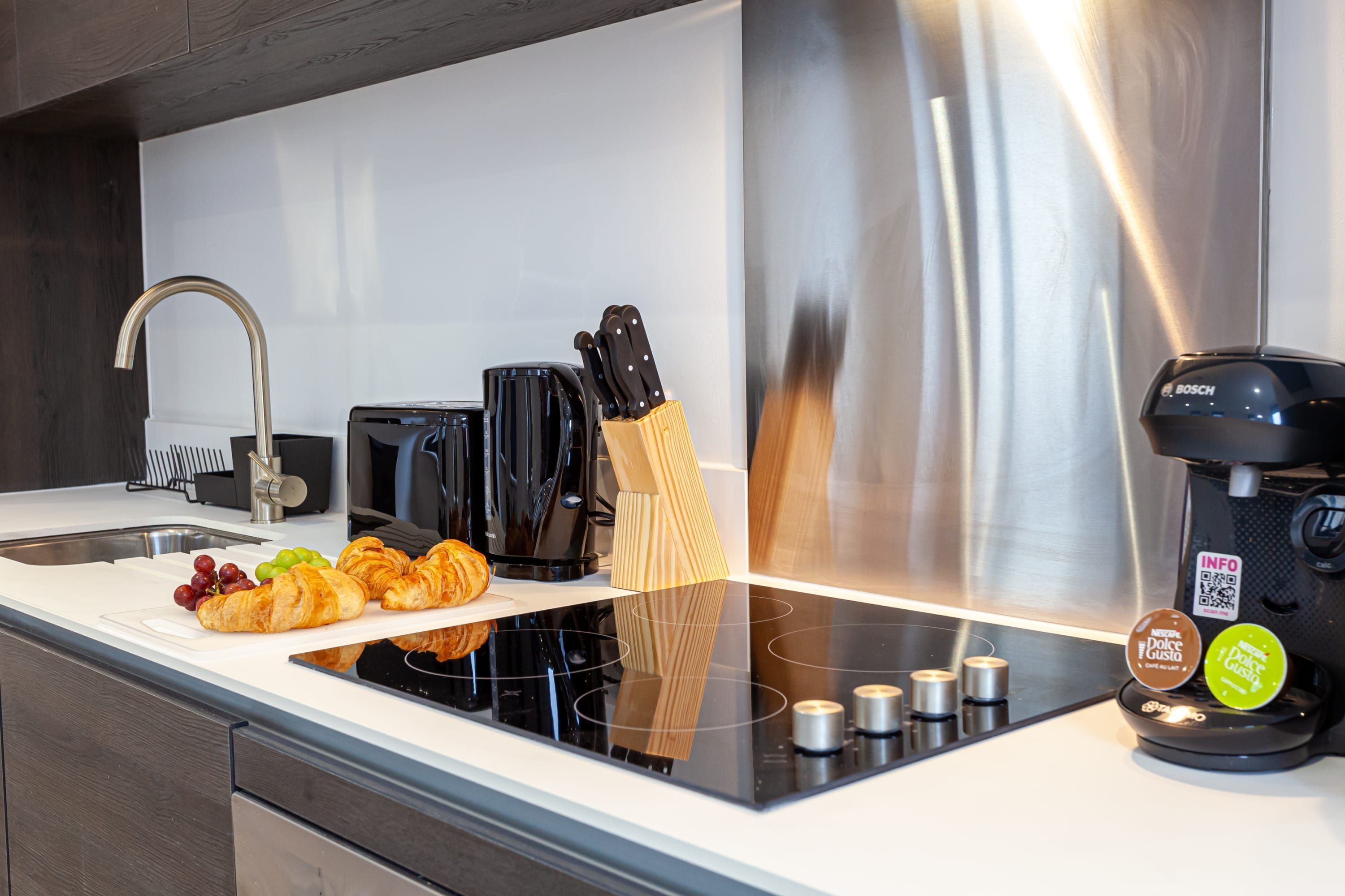 A modern kitchen with a stainless steel range, a Bosch coffee maker, and a wooden knife block.