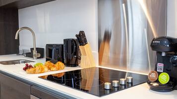 A modern kitchen with a stainless steel range, a Bosch coffee maker, and a wooden knife block.