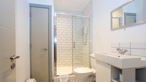 A bathroom with a shower, toilet, sink, and a mirror. - Apartment Close to City Centre and Media City By Pillo Rooms (Salford)