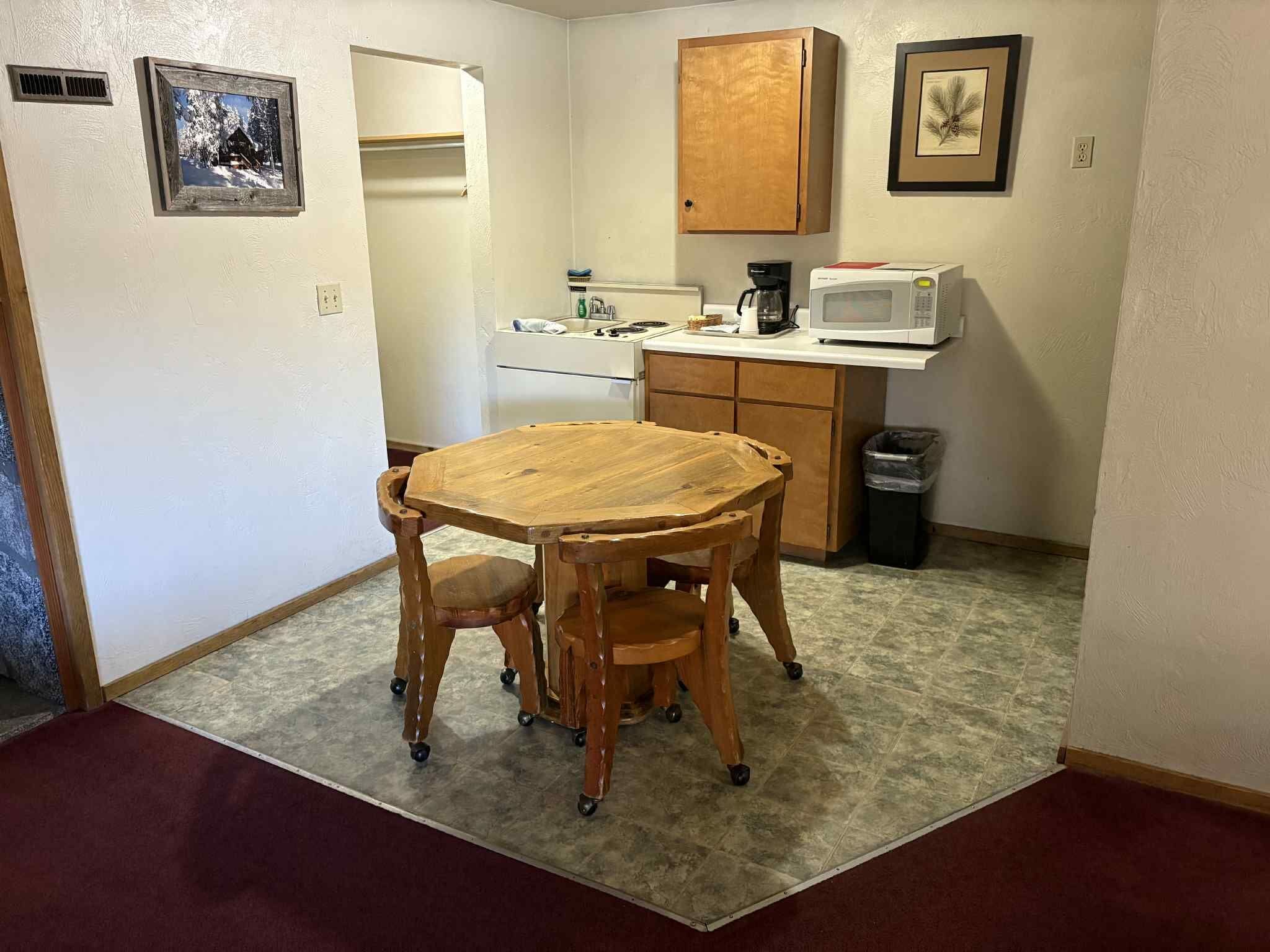 A small kitchen with a microwave, coffee maker, and a cabinet.