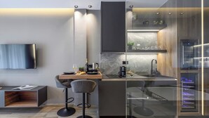A modern kitchen with a built-in oven, a coffee machine, and a wine bottle on the counter.