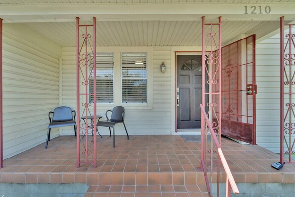A covered porch with two chairs, a door with a number, and a window with blinds. - 2 minutes to Downtown Tampa and Riverwalk (Tampa)
