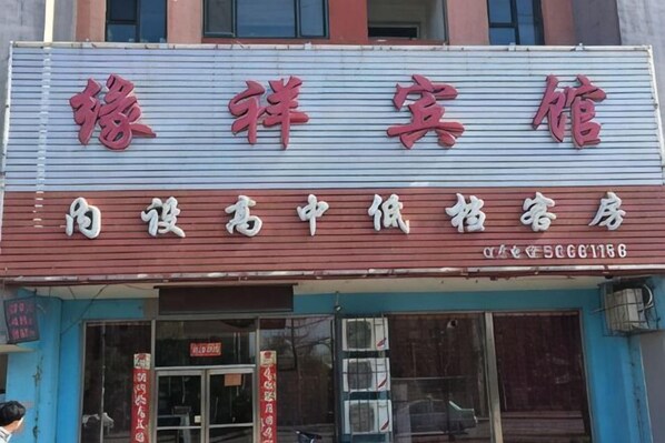 Une enseigne dâhĂŽtel avec des caractĂšres chinois et un numĂ©ro de tĂ©lĂ©phone.