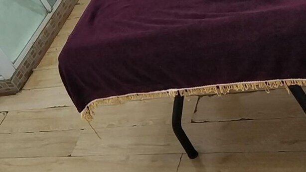 A room with a wooden floor, a purple bedspread, and a white wall. - Fushun Yuanxiang Hotel (Fushun)