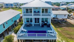 A two-story house with a balcony and a pool.
