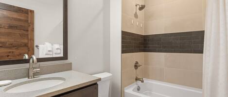 A bathroom with a sink, toilet, and bathtub.