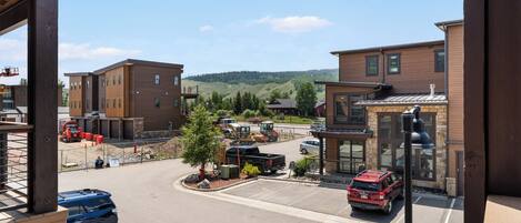 A modern building with a parking lot, construction vehicles, and a clear view of the surrounding landscape.