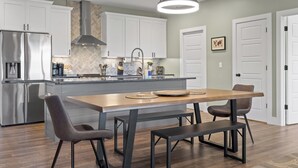 A modern kitchen with white cabinets, stainless steel appliances, and a central island with seating.