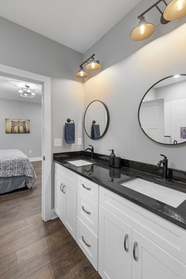 Une salle de bain moderne avec deux lavabos, un grand miroir et un éclairage au plafond.