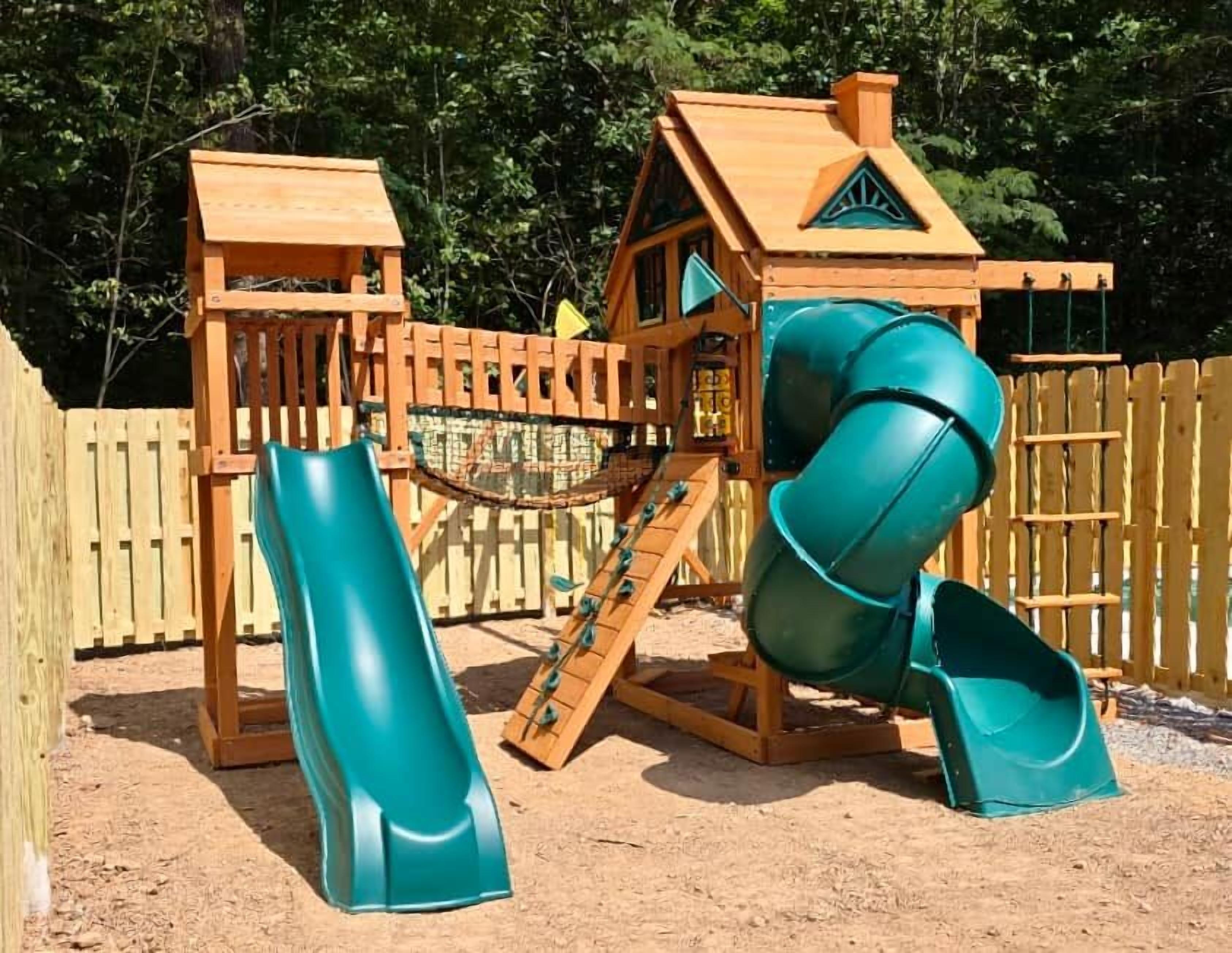 Una estructura de juego de madera con tobogán y zona de escalada.