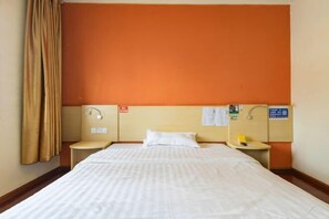 A hotel room with a large bed, two bedside tables, a nightstand, a wall-mounted lamp, and a bulletin board. - 7Days Inn Chain Hotel (Kunming Dongjiawan Telecom Building) (Kunming)