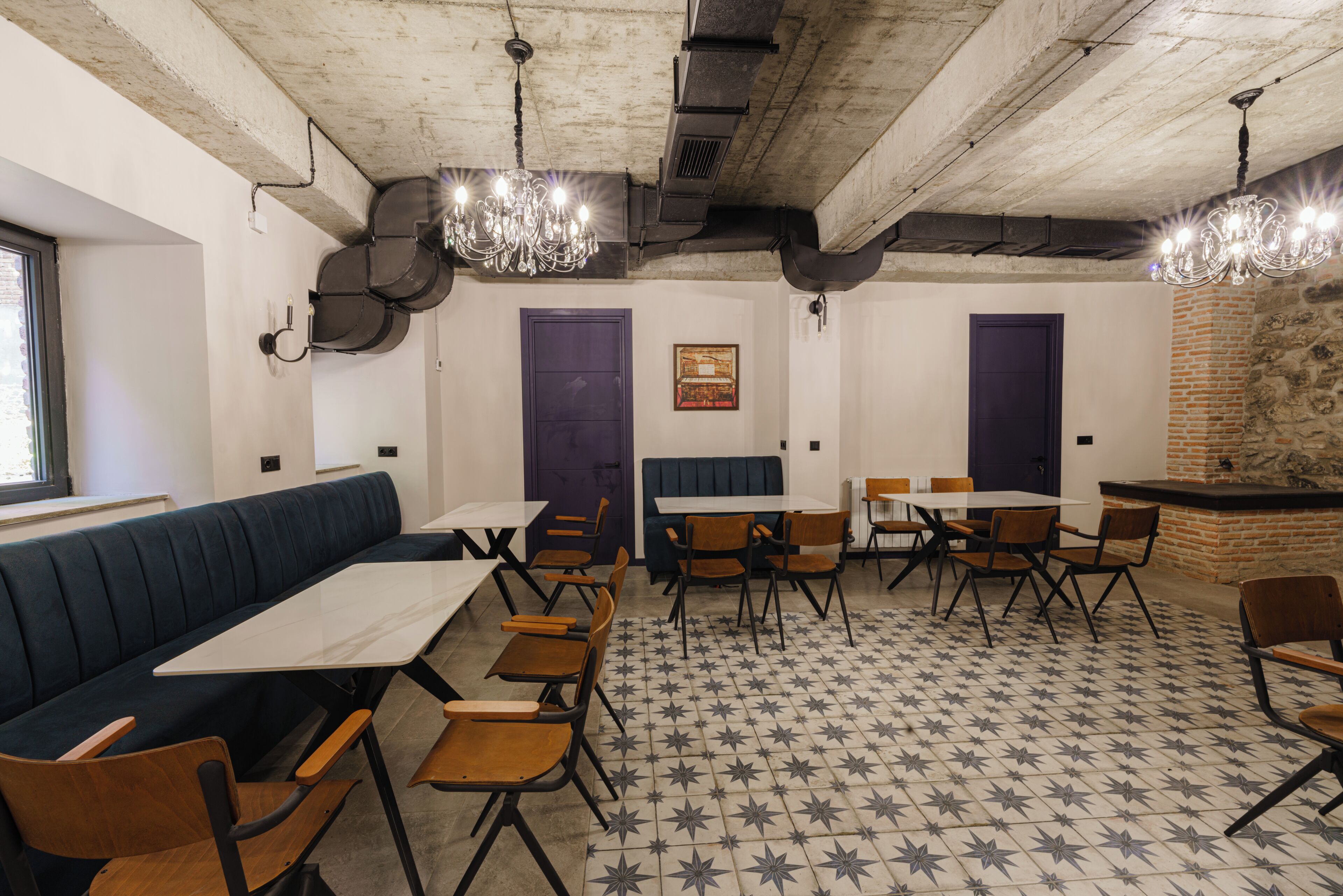 A dining area with tables and chairs, a bench, and a patterned floor.