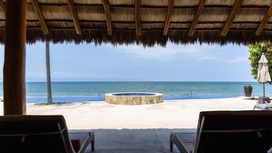A beachside lounge area with a stone fire pit, lounge chairs, and a view of the ocean. - Zenzontle - Two Level Condo Beach Facing(30 Steps) (Bucerías)