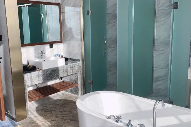 A modern bathroom with a freestanding bathtub, a vanity with a sink, and a glass-enclosed shower.