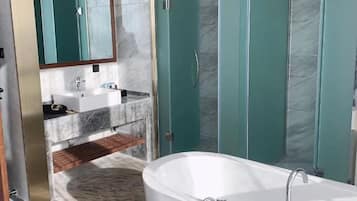 A modern bathroom with a freestanding bathtub, a vanity with a sink, and a glass-enclosed shower.