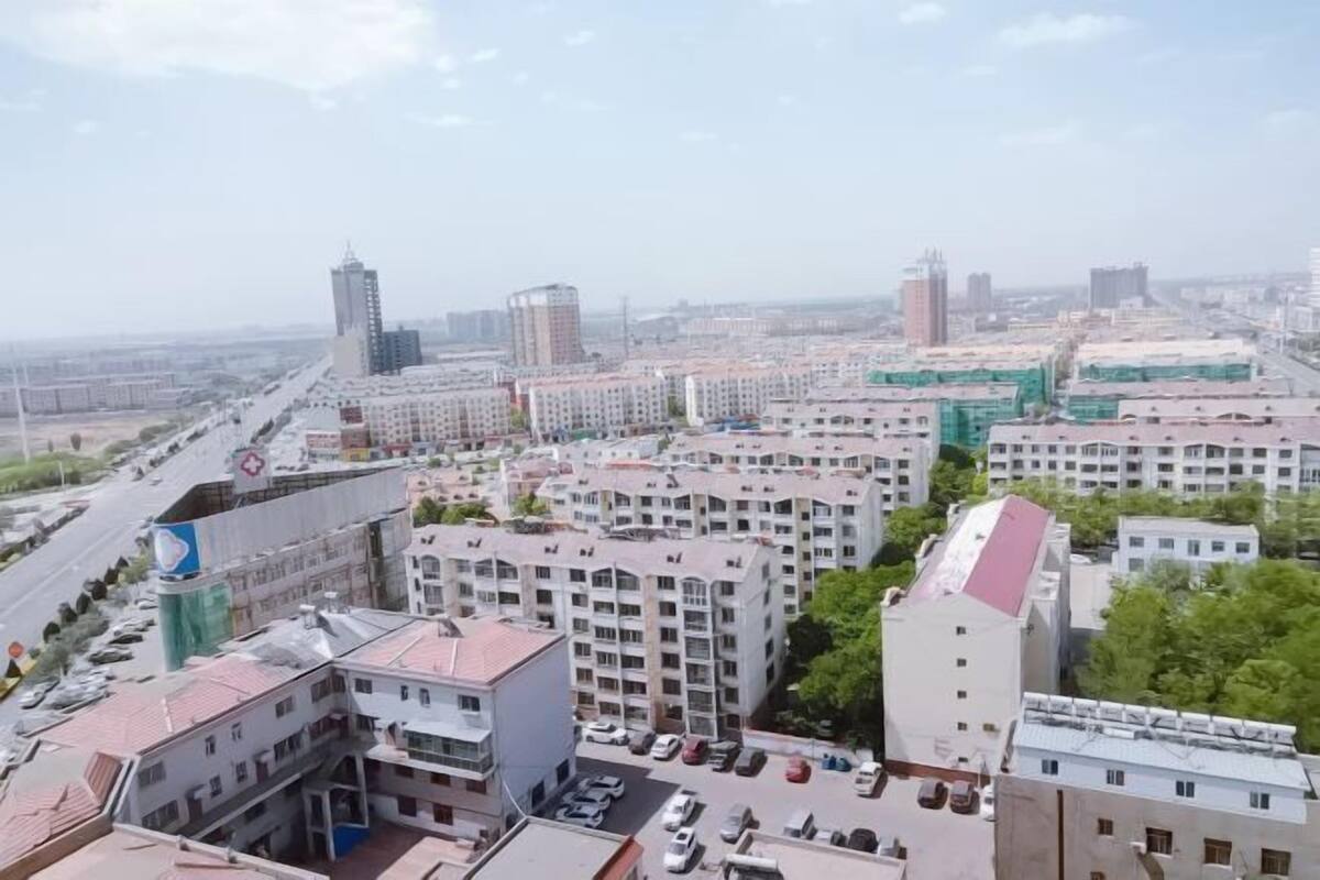 Un paisaje urbano con edificios altos, un hospital y un estacionamiento.