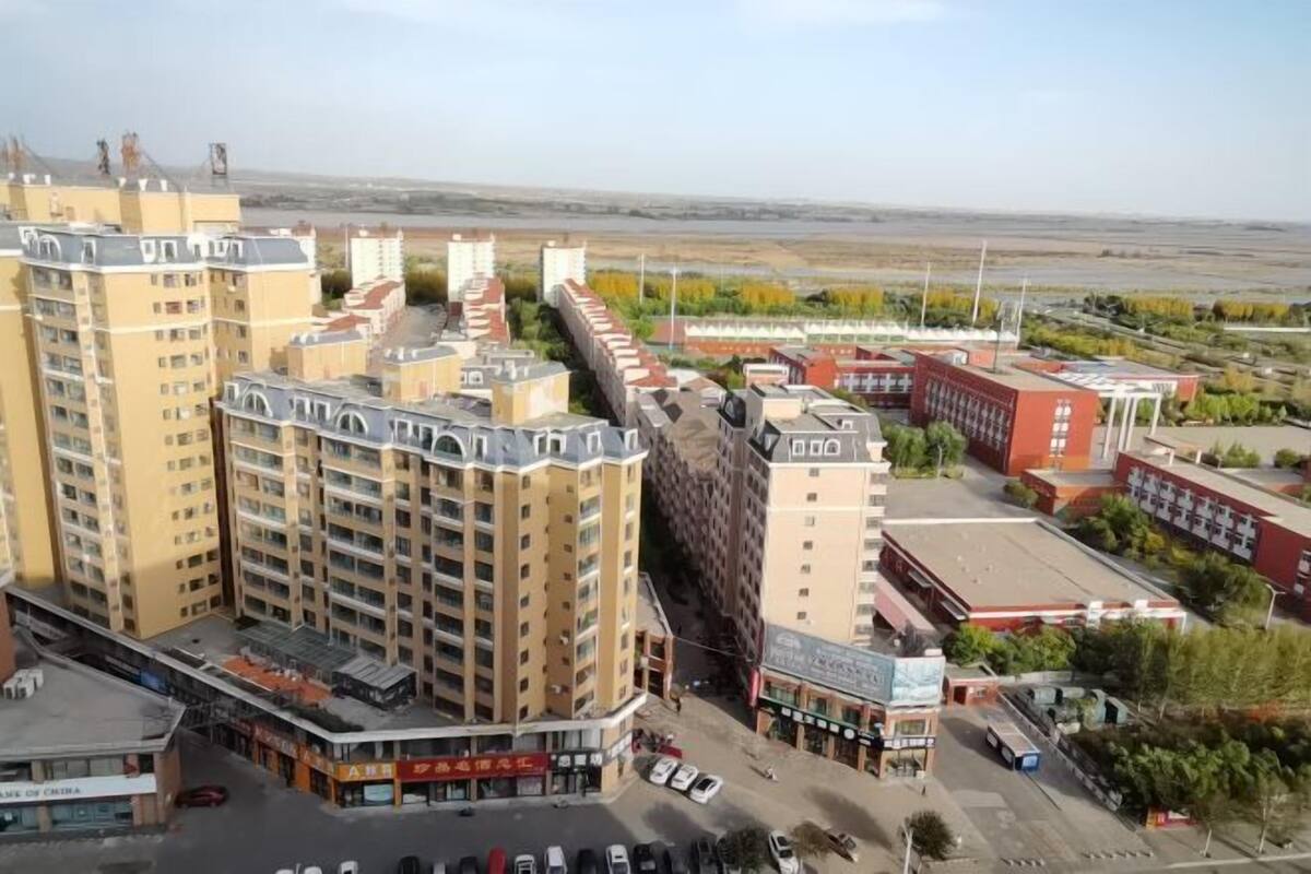 Un edificio de gran altura con varios pisos, estacionamiento y una zona comercial con tiendas.