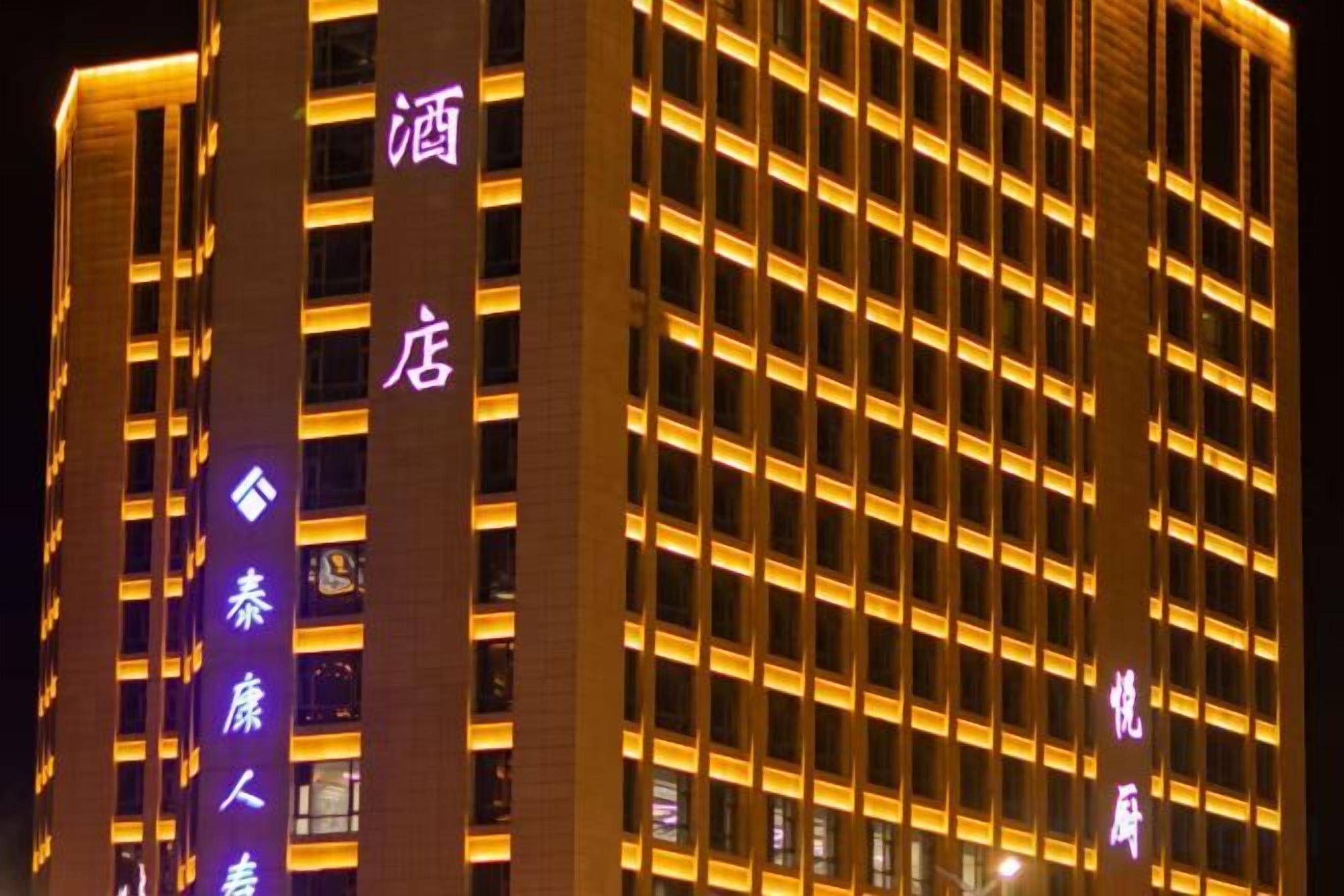 A high-rise hotel building with illuminated signage and a grid of windows.