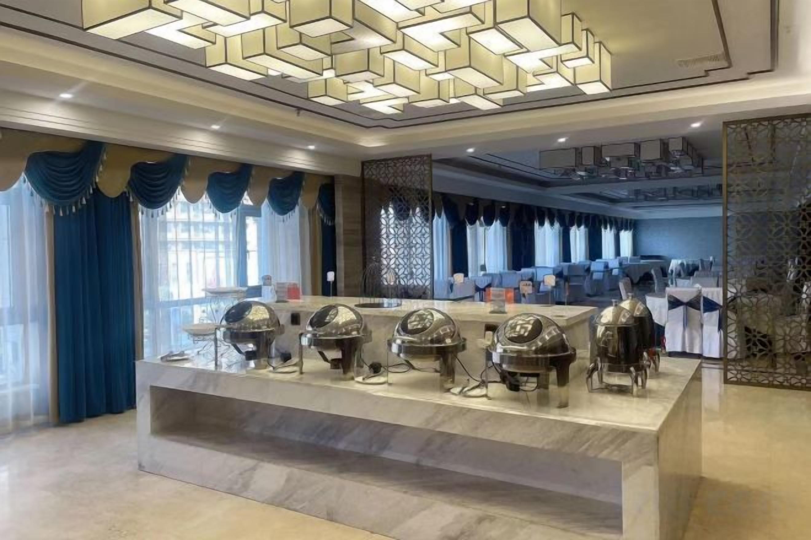 Una hall d'albergo con reception, area salotto e elementi decorativi.