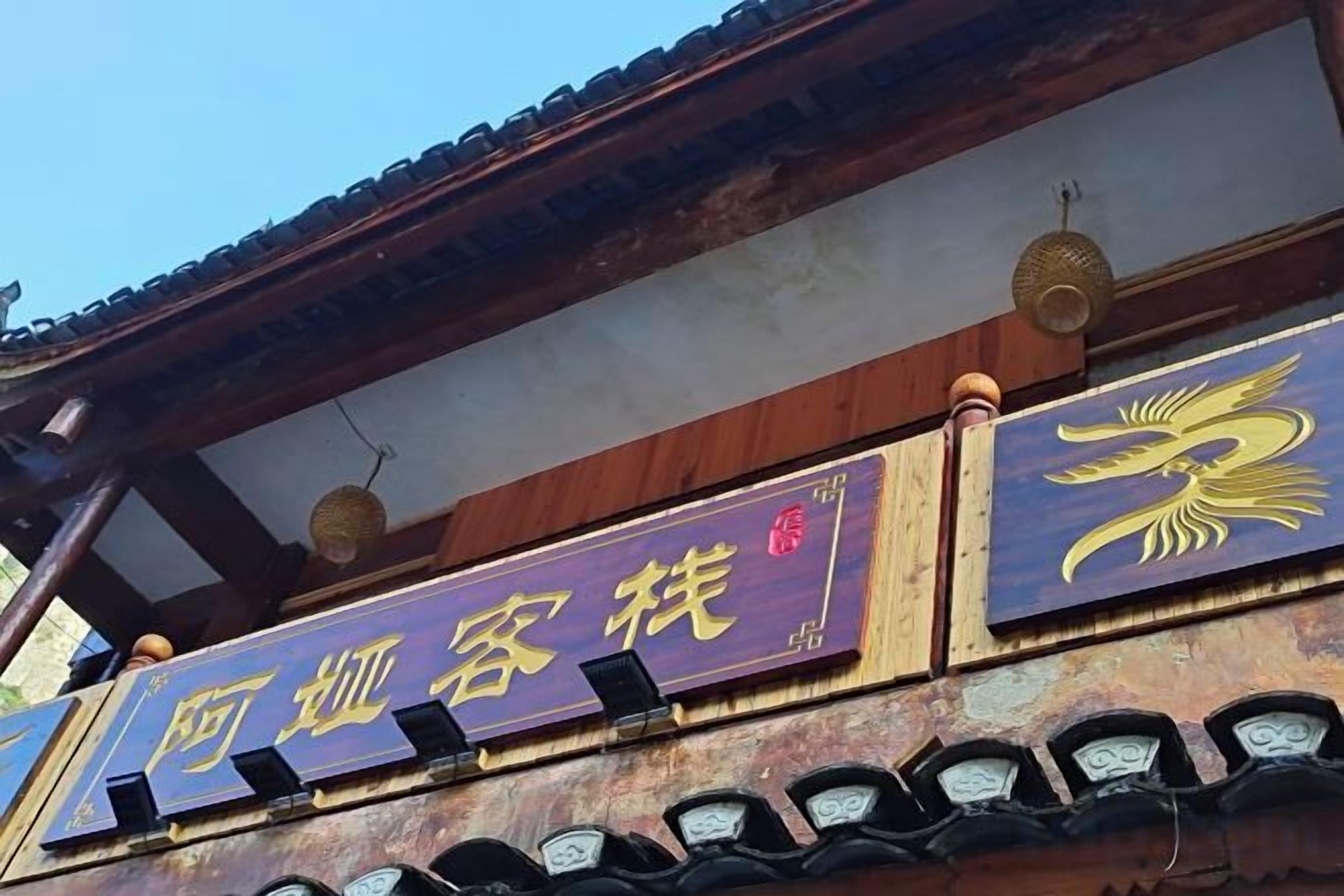 A traditional building with a sign that reads '阿川客栈' and a decorative emblem.