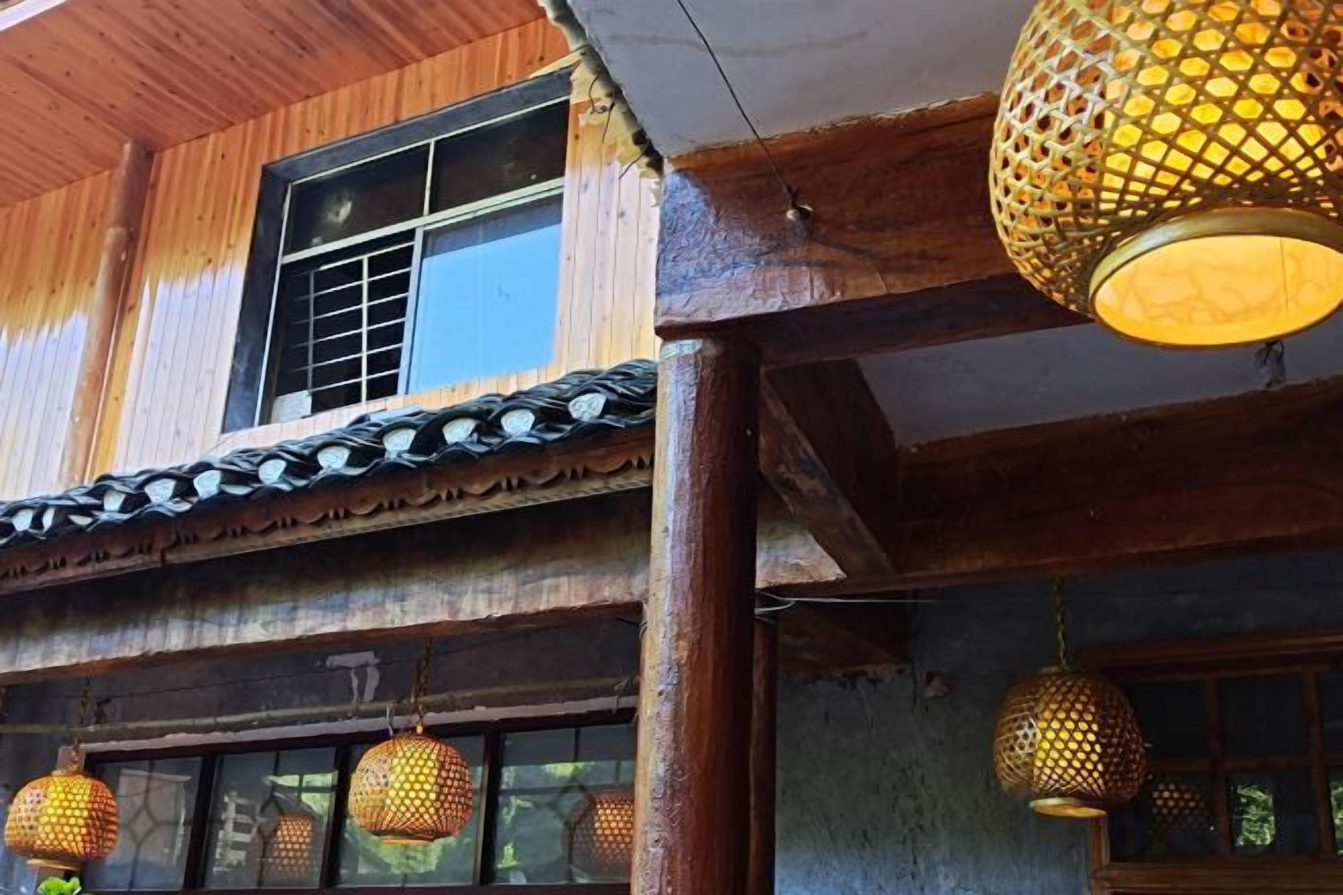 Un edificio tradicional con vigas de madera, tejado de baldosas y faroles colgantes.
