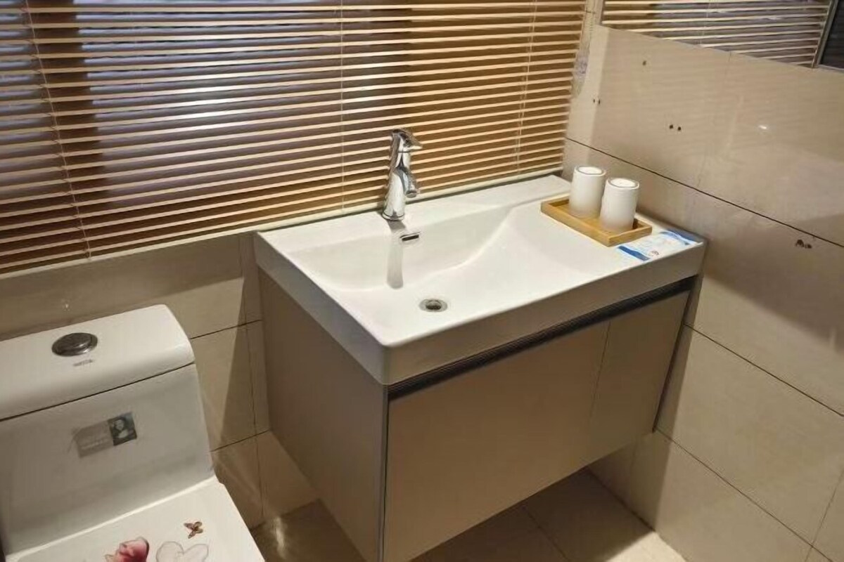 Un baño con un lavamanos blanco, un inodoro y un espejo.