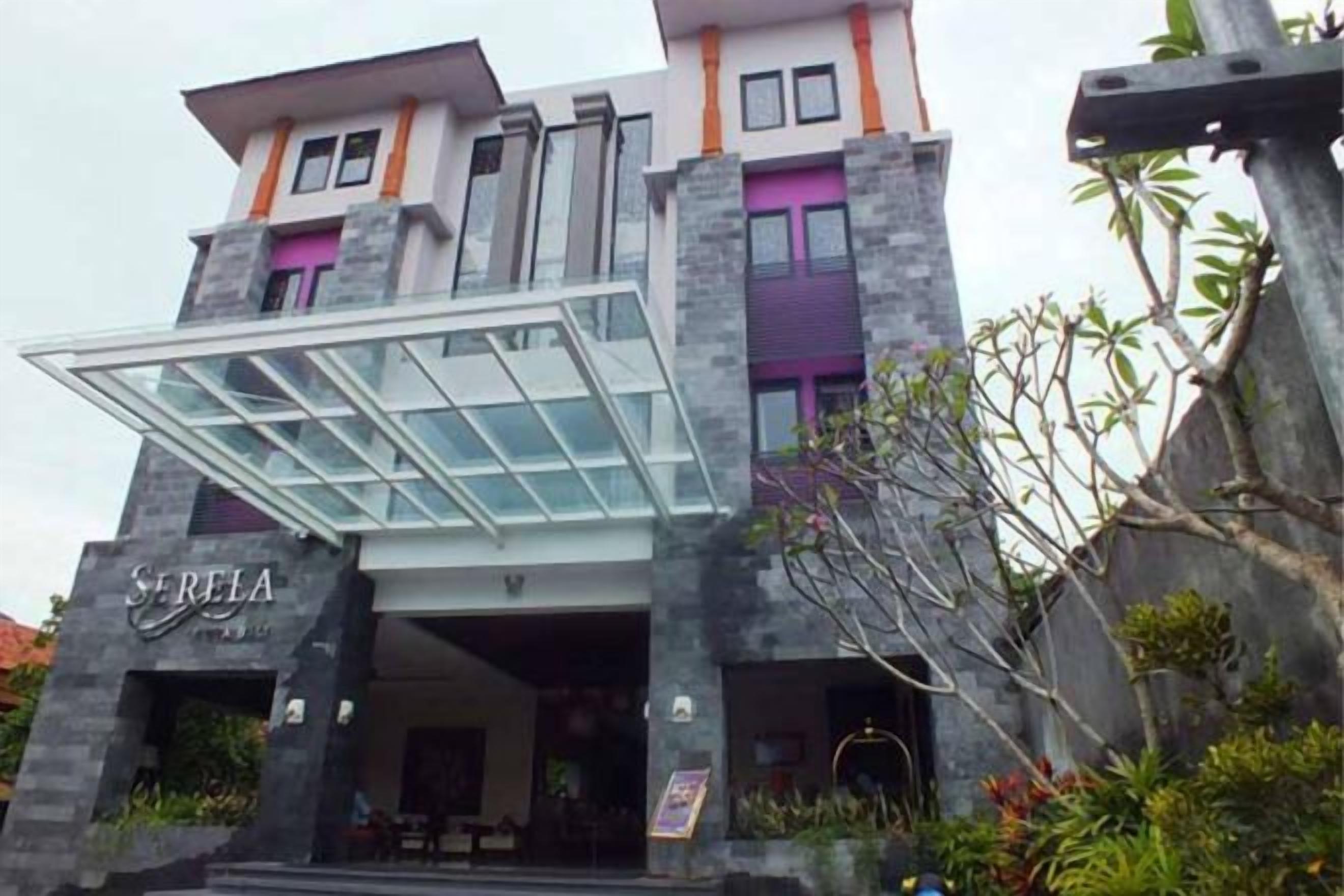 A hotel with a modern design, featuring a prominent entrance with a glass canopy and a sign that reads 'SERLA'.