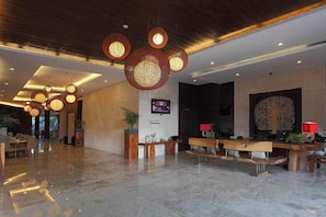 A hotel lobby with a reception desk, seating area, and decorative lighting. - Serela Kuta (Bali)