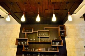 Un espace bar avec des étagères en bois et des luminaires suspendus.