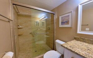 A bathroom with a glass-enclosed shower, a toilet, and a granite countertop. - Seagrape Bay 205 in Fort Myers Beach (Fort Myers Beach)
