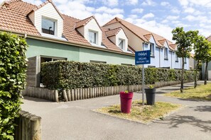 Une rangée de maisons de ville avec une enseigne indiquant « Odalys Villas 16 A 24 / 30 ».