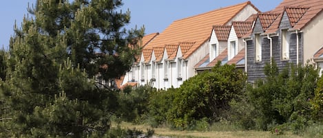 A row of houses with red-tiled roofs and white exteriors.