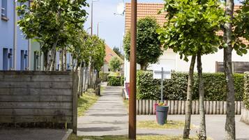 A residential street with houses, a sidewalk, and trees.