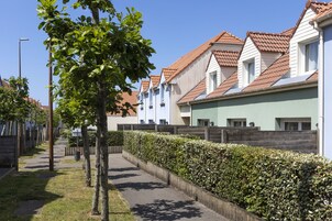 Una hilera de edificios residenciales modernos con un sendero bien cuidado y vegetación.