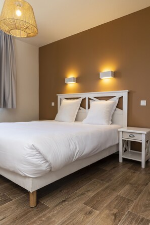 A neatly made bed with white linens, a wooden floor, and two wall-mounted lights. - Residence Les Villas De La Baie (Le Crotoy)